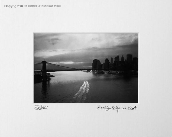 USA, New York Brooklyn Bridge and Boat on the East River at dusk. 