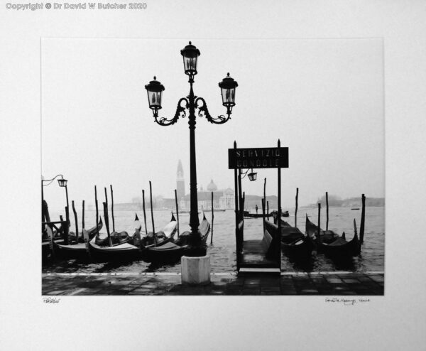 Venice Gondola Moorings and passing gondola on the lagoon near Doges Palace and St Marks Square, Palazzo San Marco, Italy