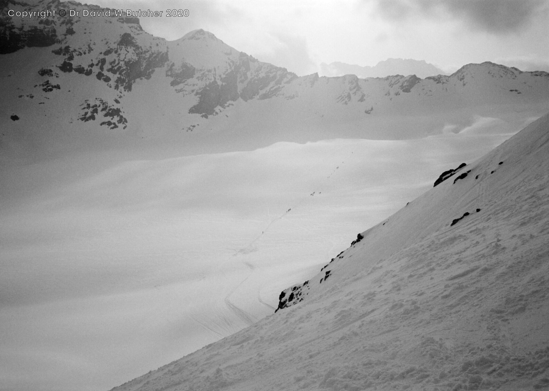 Descent from La Vierge traverse to Haut Glacier d'Arolla with line of skieers heading for Col du Mont Brule right of centre, ski Haute Route day 6